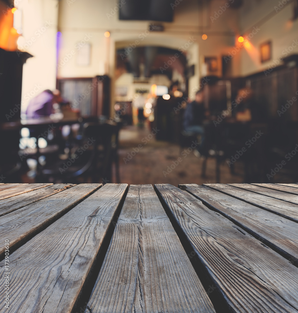 Wooden table top grunge surface over blur cafe interior background Wooden table top grunge surface over blur cafe interior background