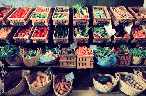 vegetables and fruits in wicker baskets in greengrocery