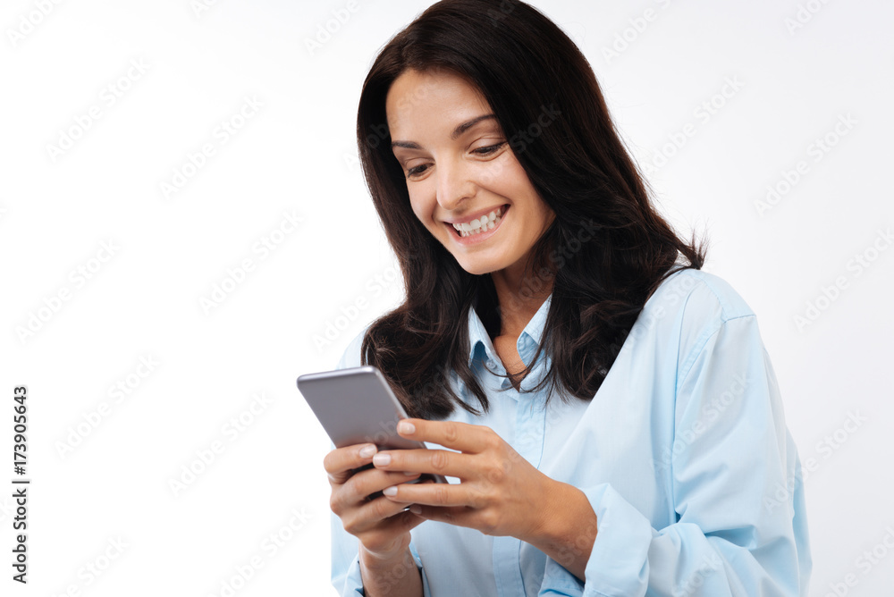 Cheerful dark-haired woman sending text message Cheerful dark-haired woman sending text message