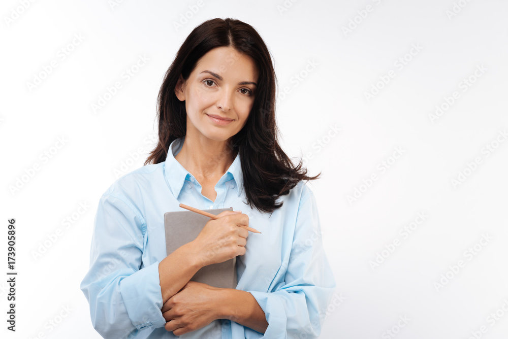 Gorgeous woman pressing daily planner to her chest Gorgeous woman pressing daily planner to her chest