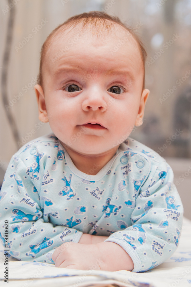 the kid lies on his stomach. Smiling child the kid lies on his stomach. Smiling child