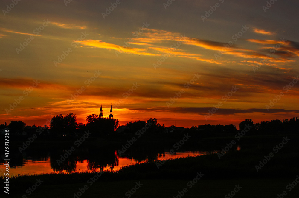 Obraz premium sunset over a river with a church
