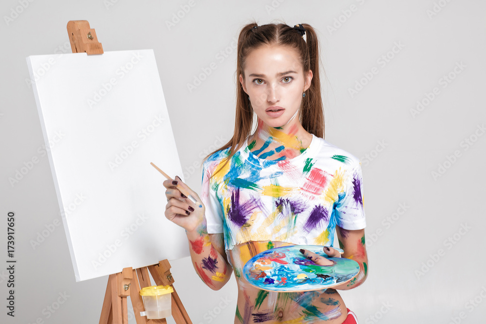 woman painter soiled in colorful paint draws on canvas. woman painter soiled in colorful paint draws on canvas.
