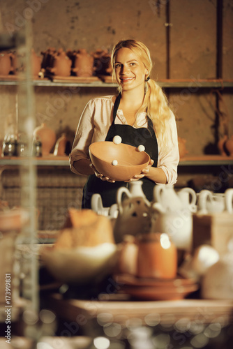 Female potter in apron in atelier.