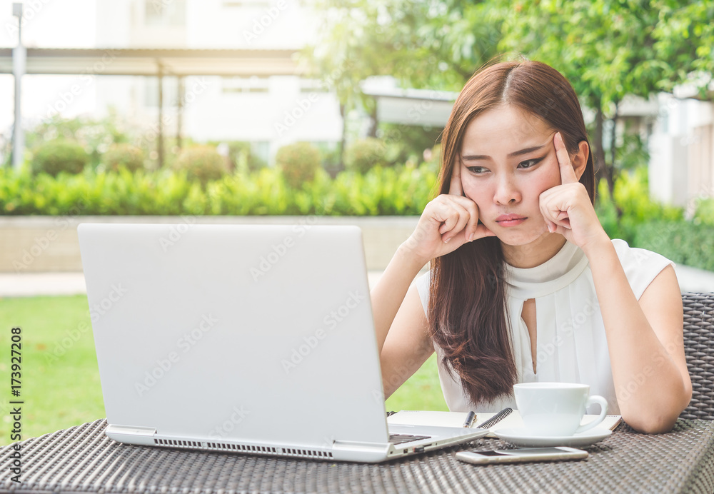 Young beautiful asian woman headache working at cafe/garden, sad, stressed, crying, disappointed feeling in the morning Young beautiful asian woman headache working at cafe/garden, sad, stressed, crying, disappointed feeling in the morning