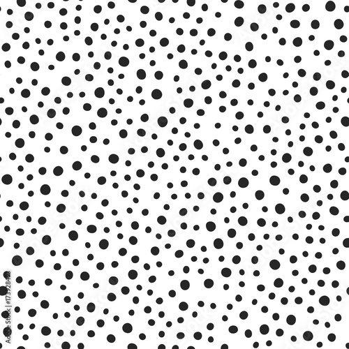 Black round spots scattered on white background. Seamless pattern. Irregular polka dot. Drawn by hand.