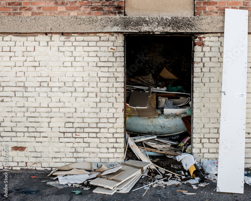 garbage on the entrance of a warehouse in disrepair