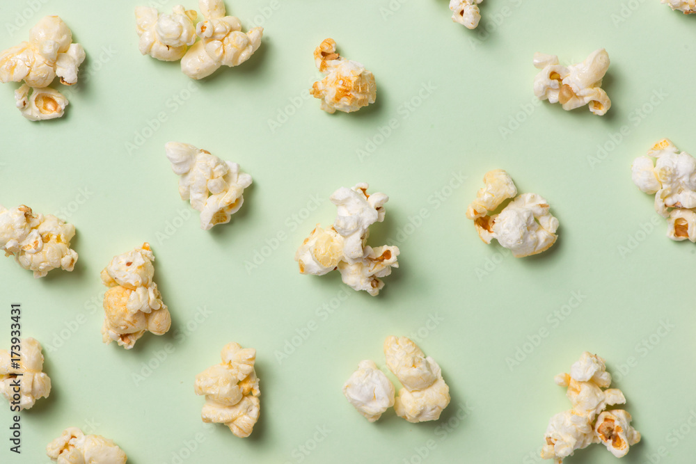 The popcorn in paper cup on green background. The popcorn in paper cup on green background.
