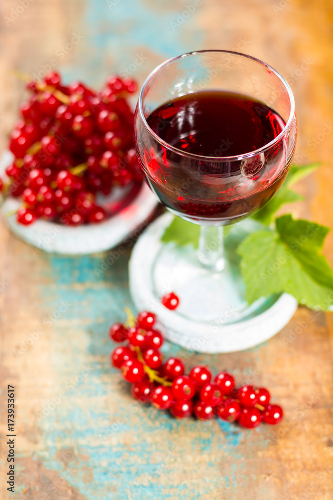 Fresh ripe red currant berries and liqueur on the table Fresh ripe red currant berries and liqueur on the table