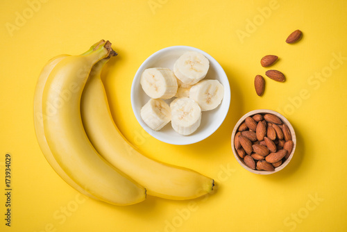 Fresh made banana smoothie in a glass on yellow background