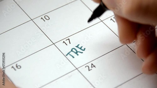 Writing TREATMENT on calendar with a green marker