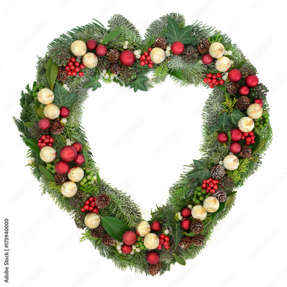 Decorative heart shaped christmas wreath with red and gold bauble decorations, holly, mistletoe, ivy, snow covered winter greenery on white background. Decorative heart shaped christmas wreath with red and gold bauble decorations, holly, mistletoe, ivy, snow covered winter greenery on white background.