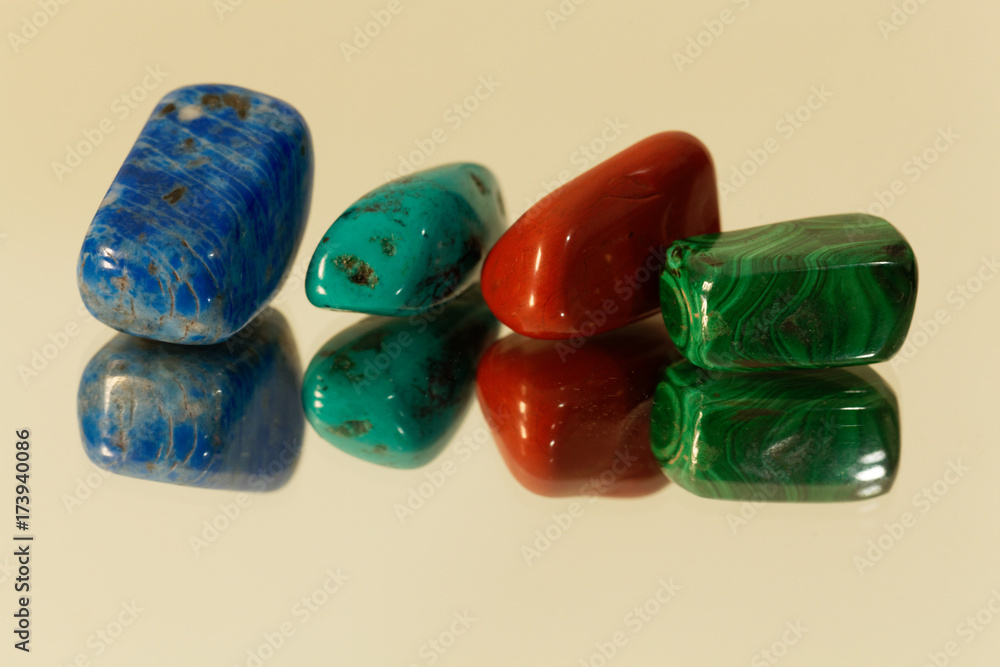 Tumbled gemstones on a mirror Tumbled gemstones on a mirror