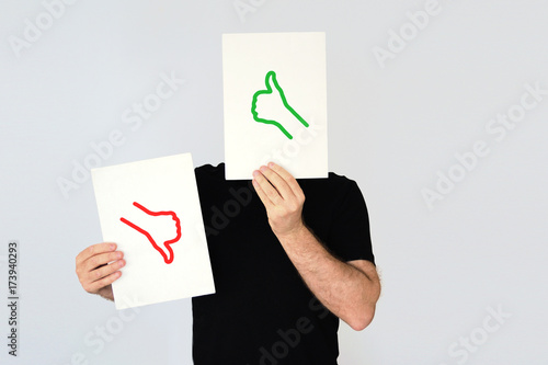 Man holding the  thumbs up and thumbs down icons. Social media and costumer feedback concept. Empty copy space for Editor's text.