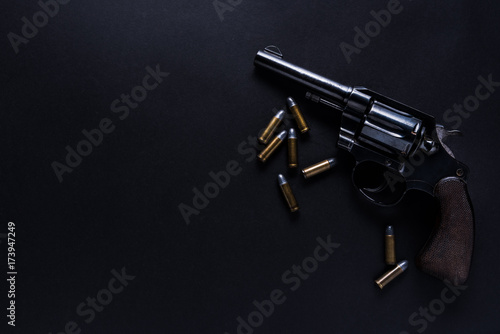 Fotografie gun with bullets on black background