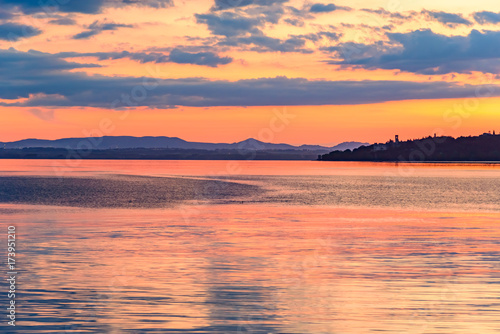 sunset over the transylvania lake in Umbria Italy intense late summer colors in the pier