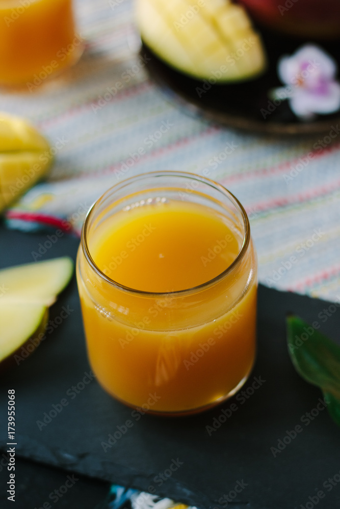 Orange and mango fruit juice over black slate. Orange and mango fruit juice over black slate.