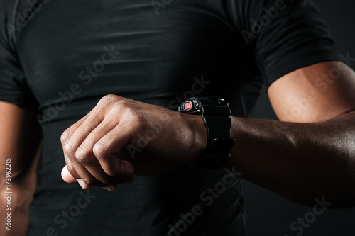 Cropped photo of afro american muscular man checking time