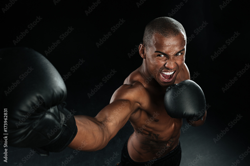 Muscular afro american man box fighter practicing kicks