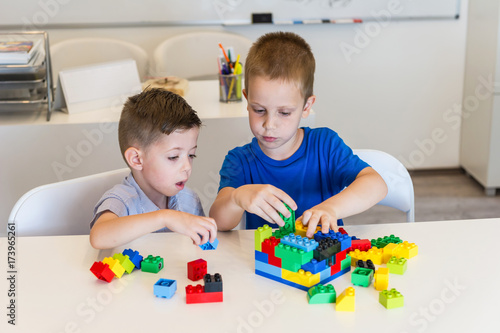 two child boy playing with cubes on the table