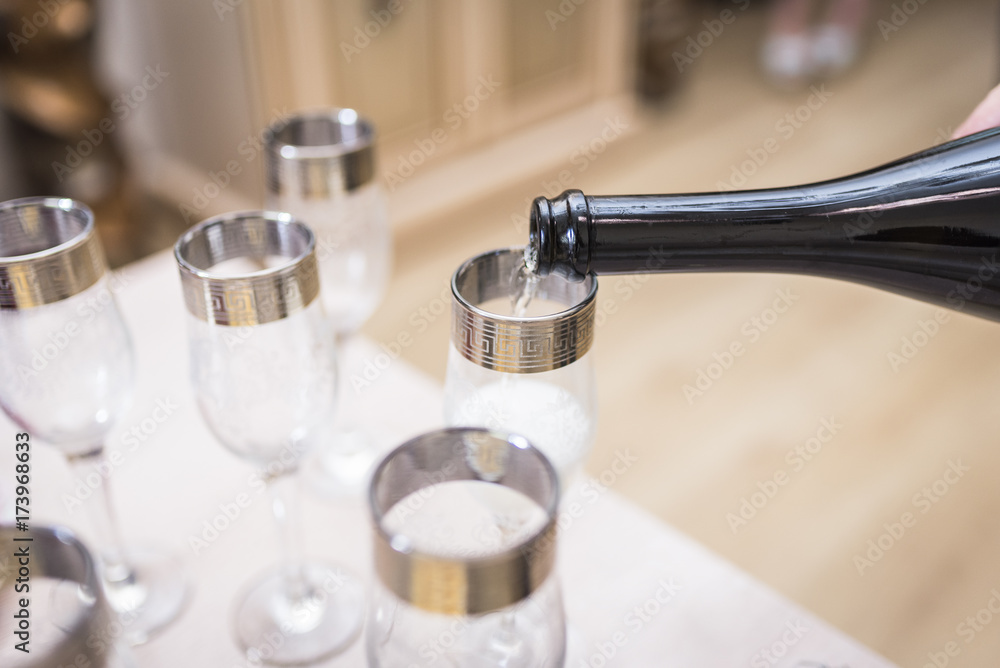 The glasses are filled with champagne from the bottle The glasses are filled with champagne from the bottle