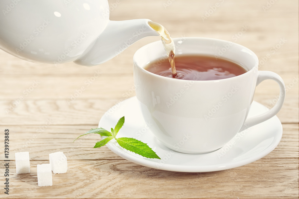 cup with green tea, sugar and teapot on light wooden table background cup with green tea, sugar and teapot on light wooden table background