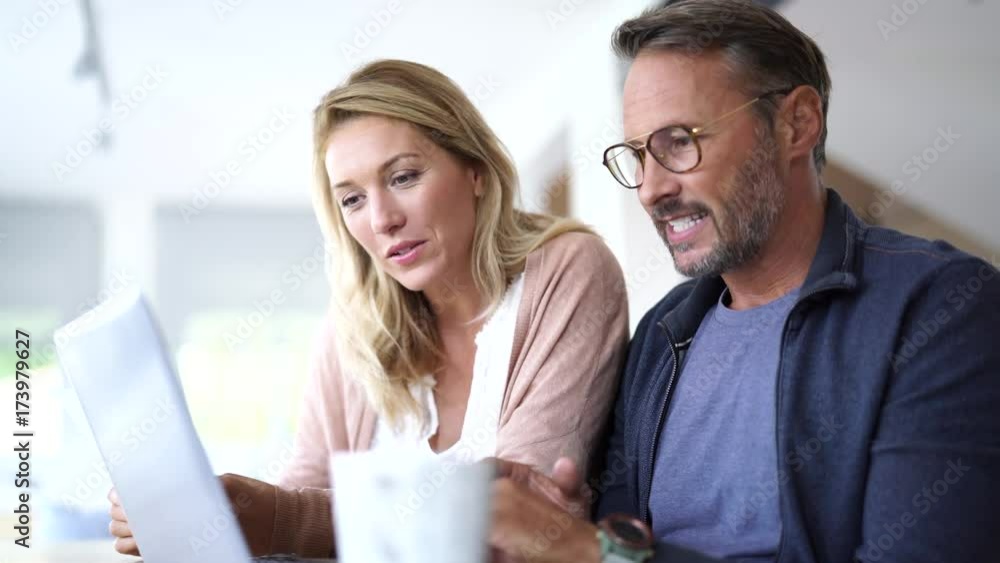 Mature couple at home working on laptop computer