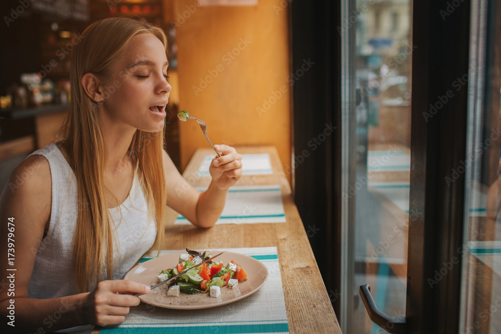 Portrait of attractive caucasian smiling woman eating salad