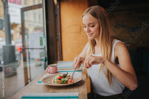 Photographie Portrait of attractive caucasian smiling woman eating salad