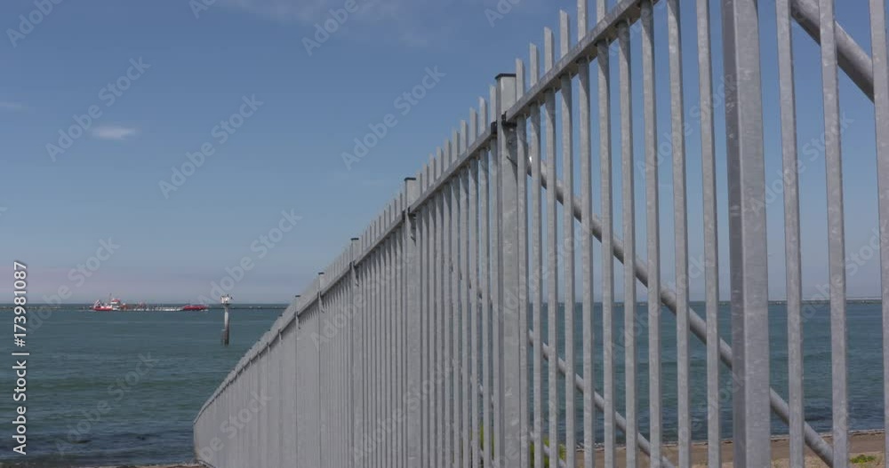fenced slope of the dike into sea at Eurogate, entrance to Europe. SEAPORT ROTTERDAM: fenced slope of the dike into sea at Eurogate, entrance to Europe. SEAPORT ROTTERDAM: