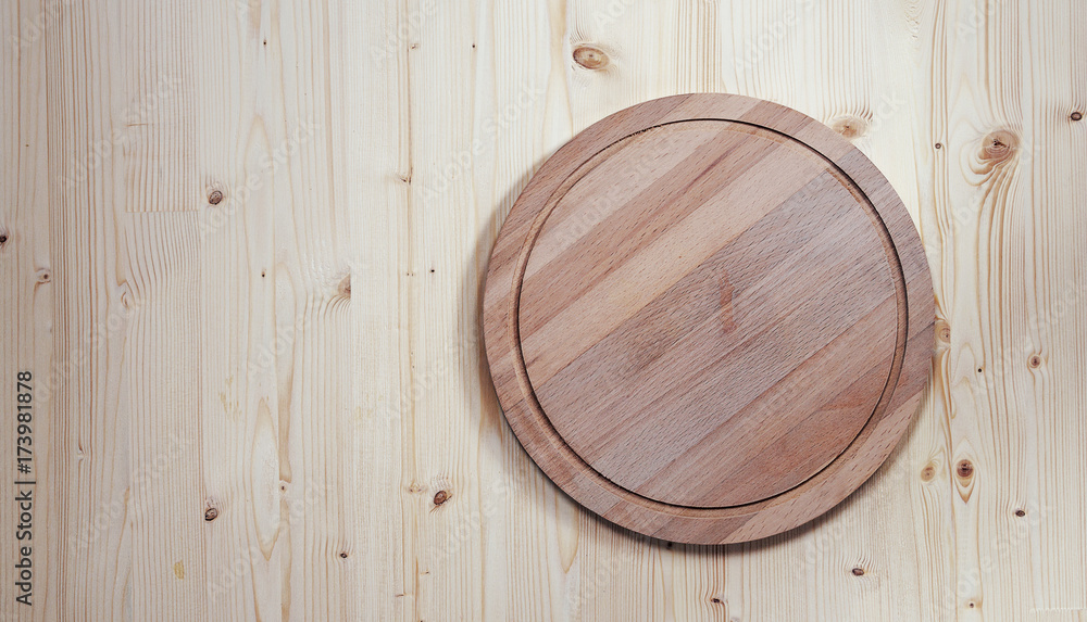 empty round wooden board for cutting on a wooden background empty round wooden board for cutting on a wooden background