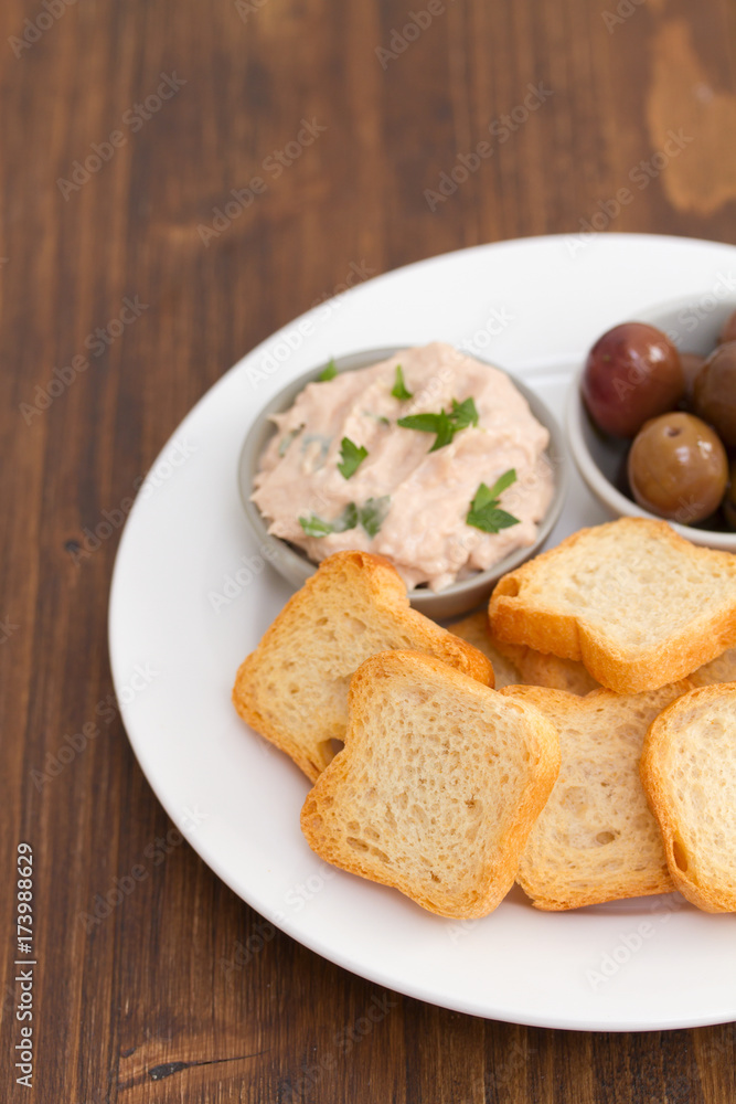 toasts with fish pate and olives on white plate toasts with fish pate and olives on white plate