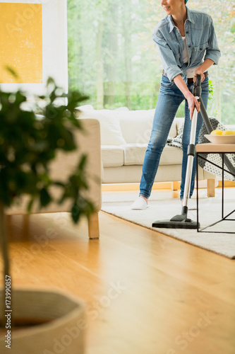 Woman vacuum carpet in house