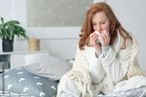 Miserable woman blowing runny nose