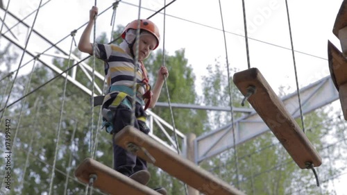 Wallpaper Mural Little cute boy enjoying activity in a climbing adventure park on a summer sunny day. toddler climbing in a rope playground structure. Safe Climbing extreme sport with helmet and Carabiner. insurance Torontodigital.ca