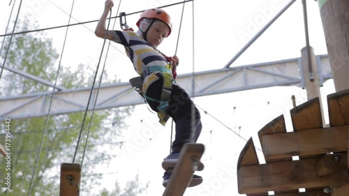 Wallpaper Mural Little cute boy enjoying activity in a climbing adventure park on a summer sunny day. toddler climbing in a rope playground structure. Safe Climbing extreme sport with helmet and Carabiner. insurance Torontodigital.ca