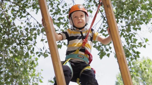 Wallpaper Mural Little cute boy enjoying activity in a climbing adventure park on a summer sunny day. toddler climbing in a rope playground structure. Safe Climbing extreme sport with helmet and Carabiner. insurance Torontodigital.ca