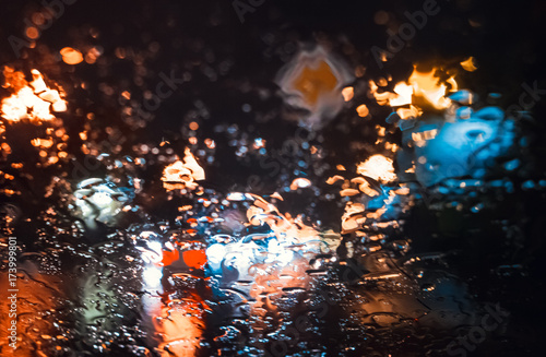Magnificent city landscape in the side through the wet windshield of the car in the rain. Beautiful background © oktopusss