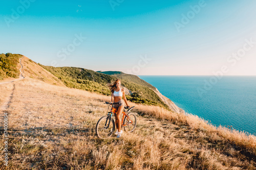Fototapeta Naklejka Na Ścianę i Meble -  Happy woman on a bicycle relax in outdoors and sea background