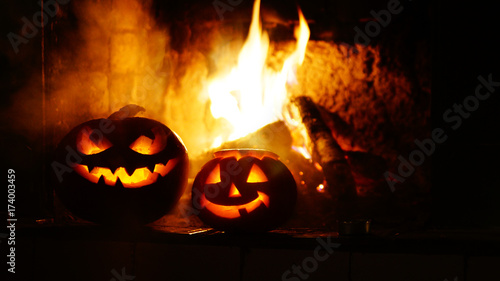 Creepy halloween pumpkins near a fireplace. Fire on the background.