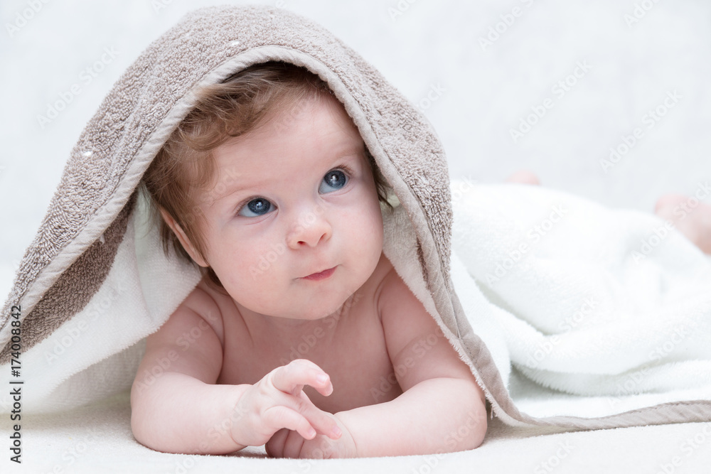 Cute baby after bath, parental care concept. Happy baby having fun. Three-months old baby looking up Cute baby after bath, parental care concept. Happy baby having fun. Three-months old baby looking up