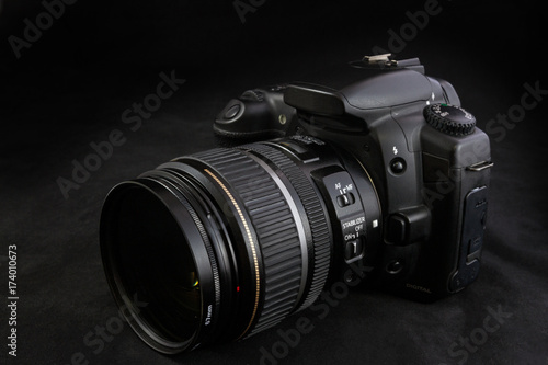 One black camera with zoom lens isolated on black background