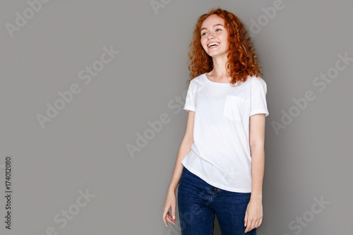 Laughing girl in casual clothes posing at studio
