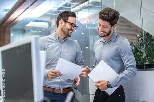 Two businessmen discussing document in office. © Bojan