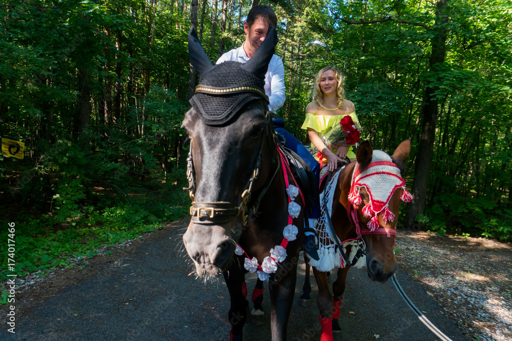 Fototapeta premium Young couple in love riding a horse