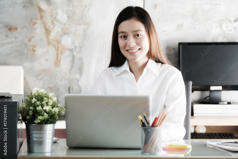 Young asian businesswoman working with with smiling face at office desk, positive emotion, office life concept Young asian businesswoman working with with smiling face at office desk, positive emotion, office life concept