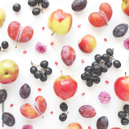 Vertical  composition of fruits on a white background. Pattern made from fresh fruits. Top view  flat design. Collage of plum  grapes  flowers. 