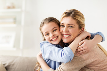 happy smiling family hugging on sofa at home