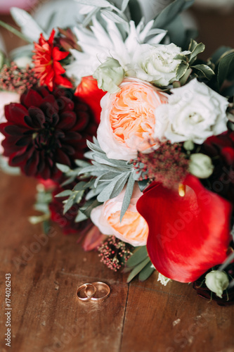 wedding rings with bouquet and blurred background