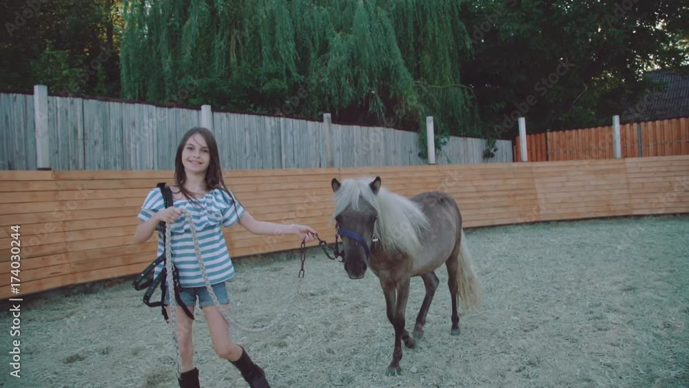 Pretty girl walks with a beautiful pony on the arena. 4K Pretty girl walks with a beautiful pony on the arena. 4K